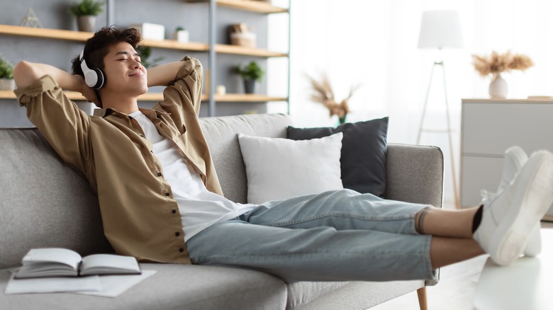 Man sitting on couch wearing headphones