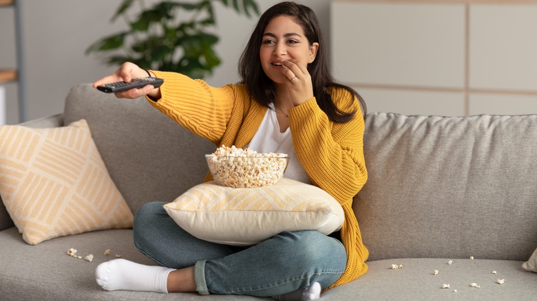 Woman eating popcorn watching TV