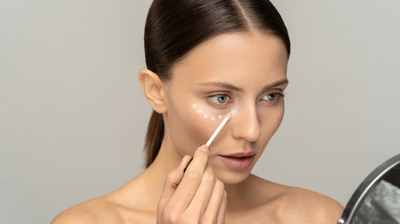 woman applying undereye concealer