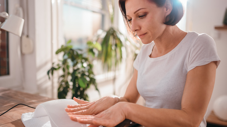 A woman looking at her nails 