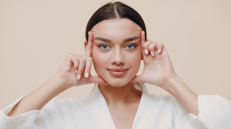 woman lifting eyebrows with fingers