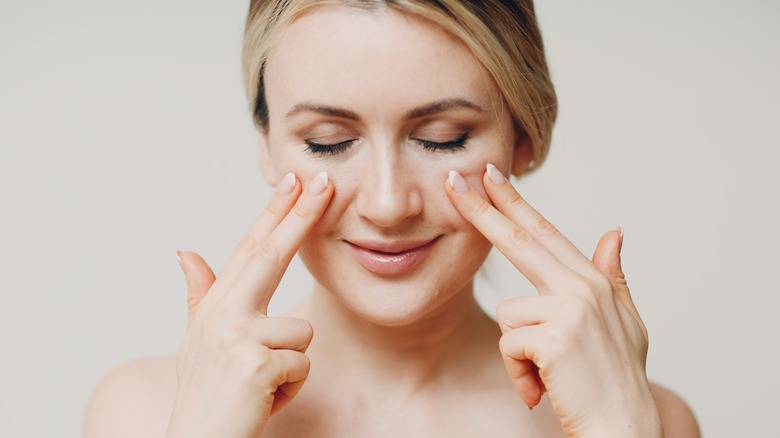 woman running fingers up cheeks