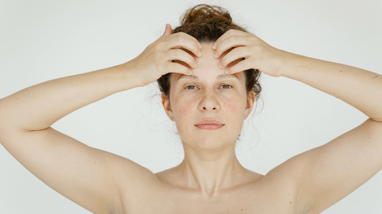 woman pressing on frown lines