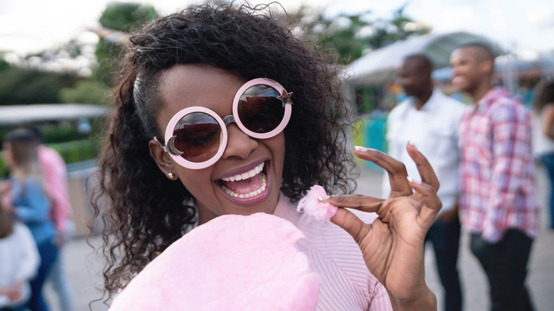 Smiling woman eating cotton candy