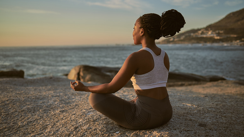 Woman meditating on beach