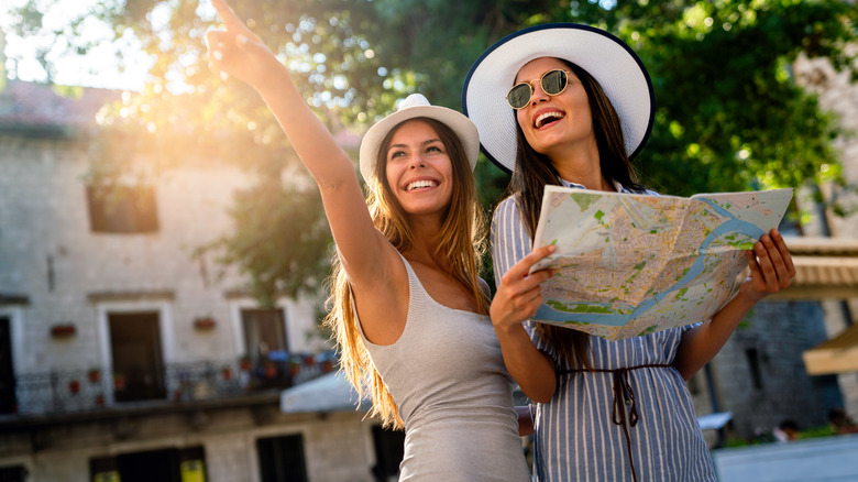 Friends smiling and pointing with map