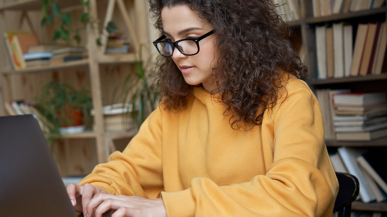 Focused woman writing at laptop 