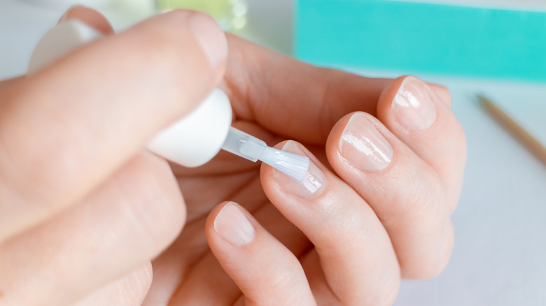 applying base coat on nails 