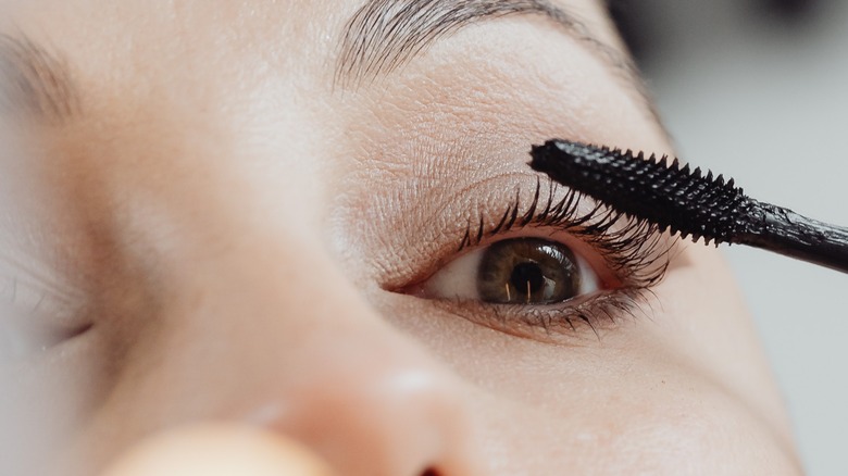 female applying mascara