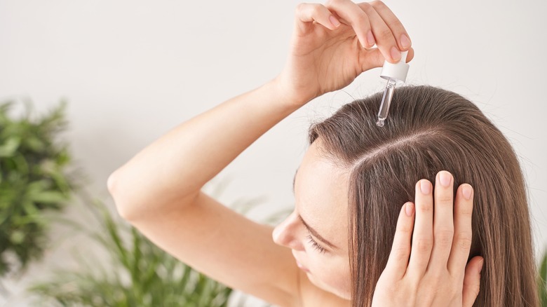 Woman treating scalp dropper