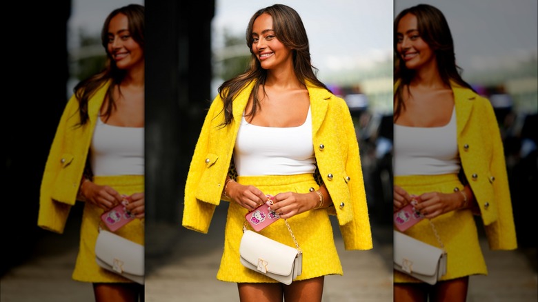 Woman wearing yellow tweed skirt set