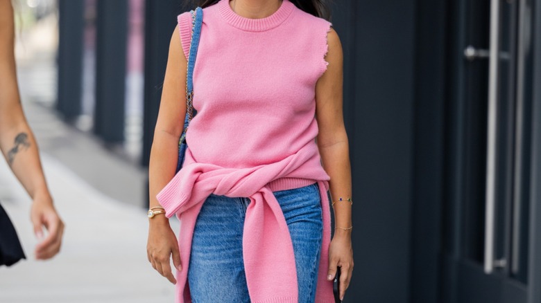 woman wearing pink sweater around waist