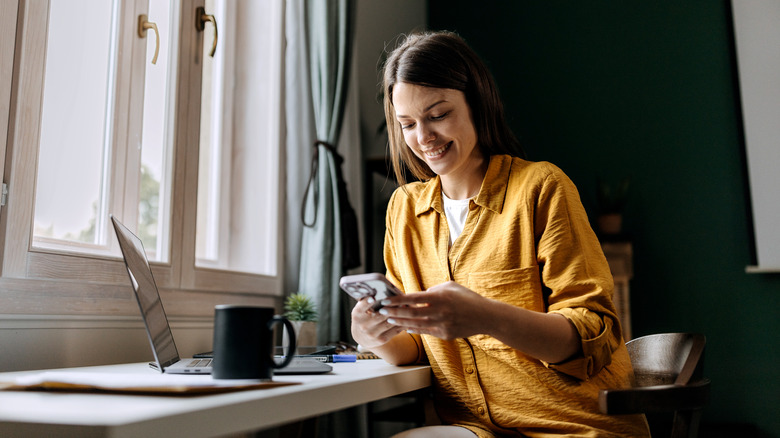 Woman smiles at phone screen 