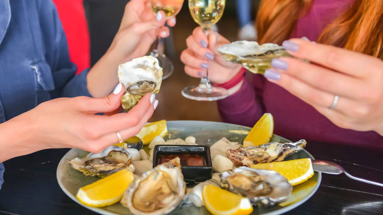 two women holding oysters 