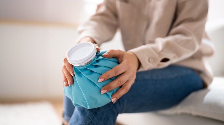 woman applying ice to knee