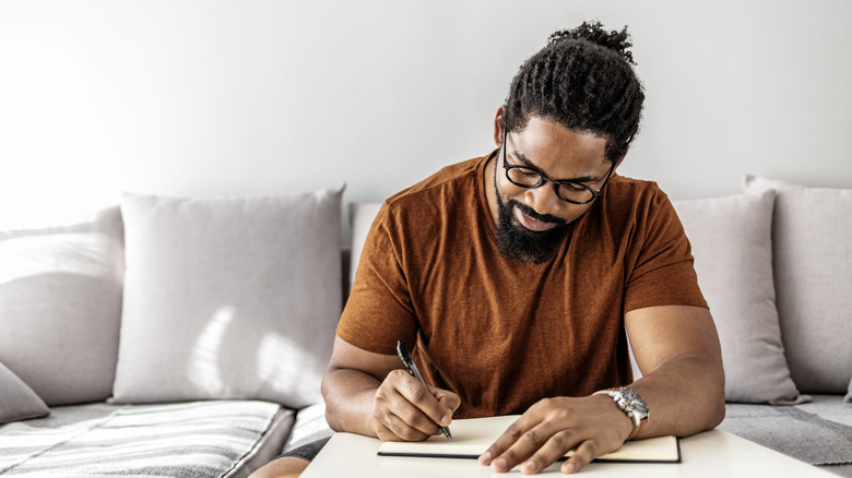 Man writing in journal 