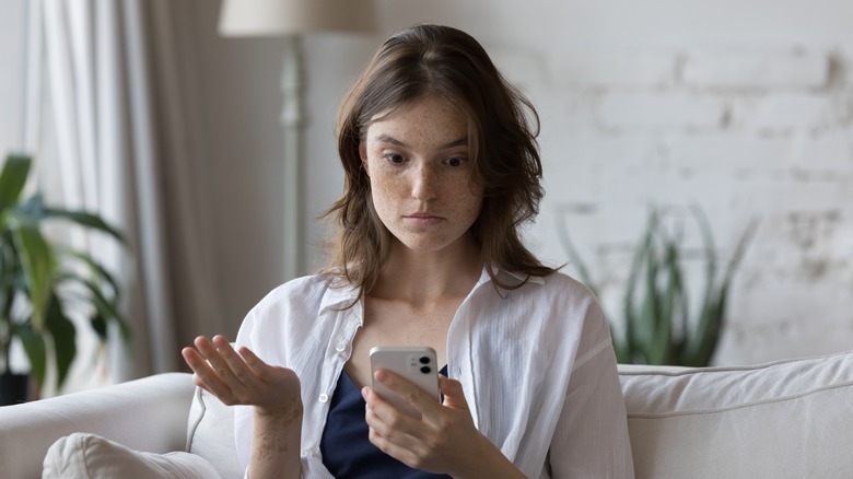 Annoyed woman looking at phone