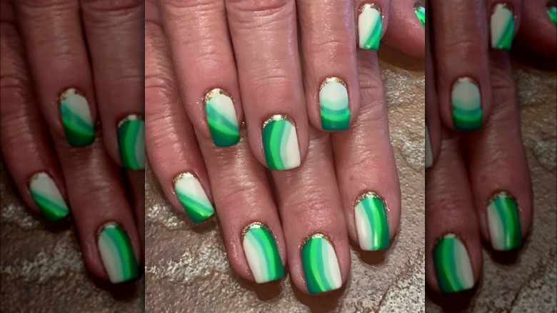 green swirl manicure with gold cuff
