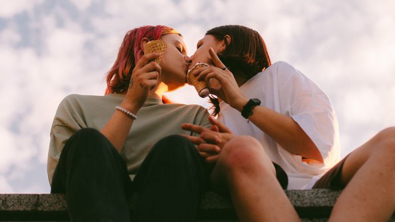 Kissing couple holding ice cream cones