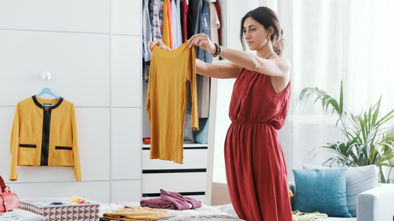 Woman sorting clothes in bedroom