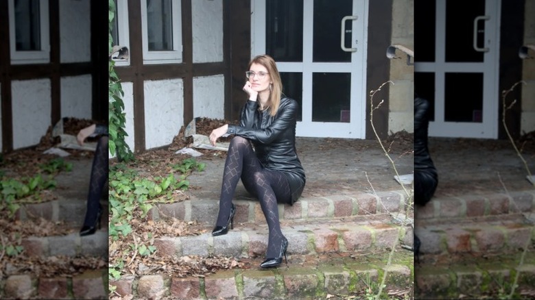 Woman sitting, wearing black tights