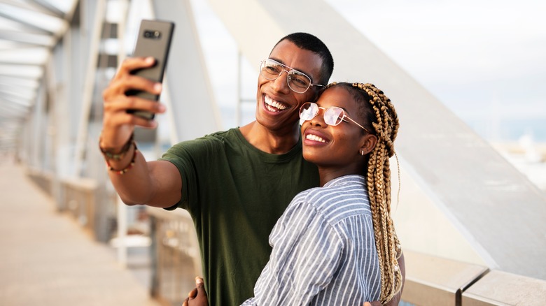 young Black couple smiling and take selfie