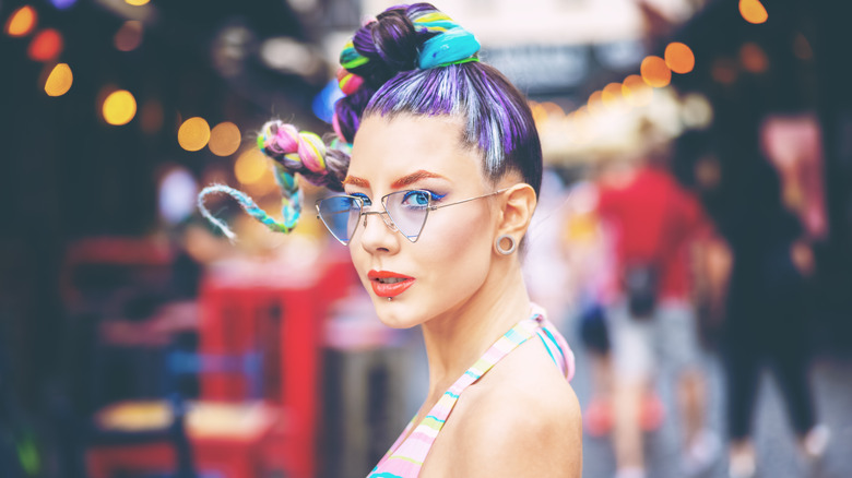 Woman models eccentric hairstyle, makeup, and clothing 