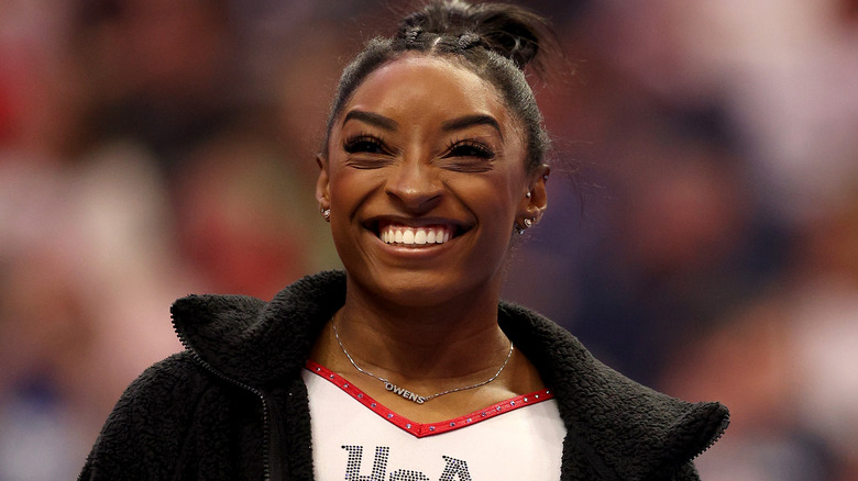 Simone Biles smiling black jacket