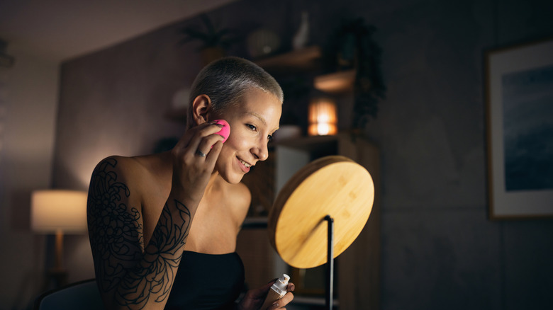 Woman doing her makeup in the mirror