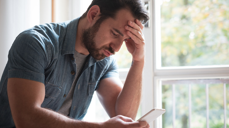 man looking unimpressed at phone