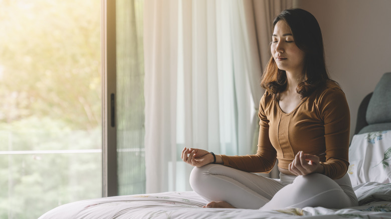 Woman meditating on bed
