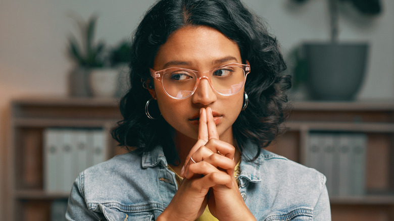 Woman holding fingers over her lips