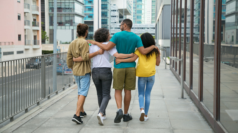 Four people, arms around each other