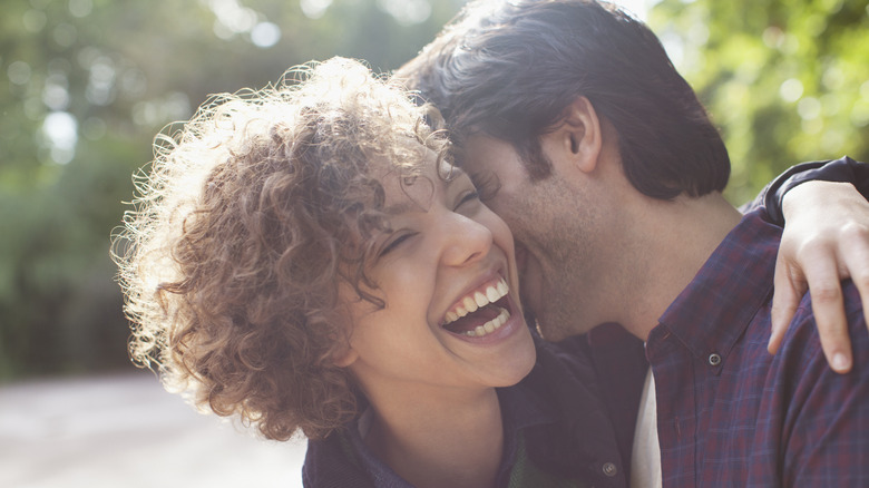 Man kissing woman on cheek