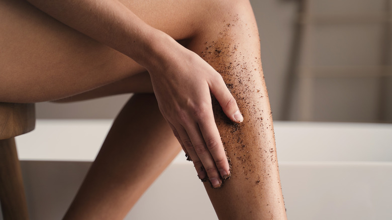 woman using scrub on legs