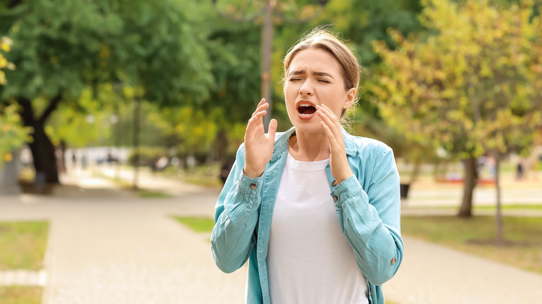 woman sneezing from pollen allergy