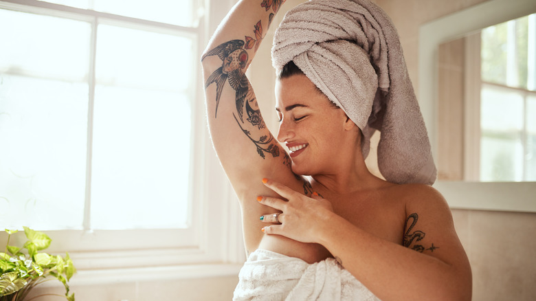 Woman in bathroom lifts arm