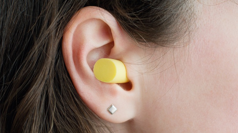 Woman wearing yellow earplug 