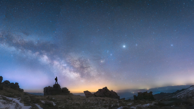 Person standing on rock stargazing