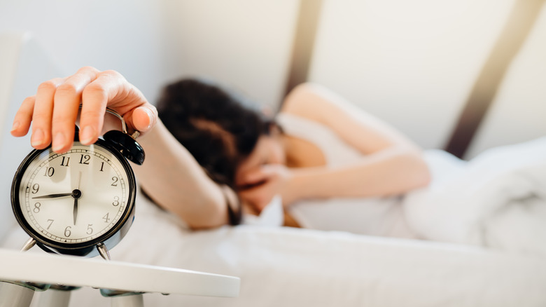 Woman turning off a clock