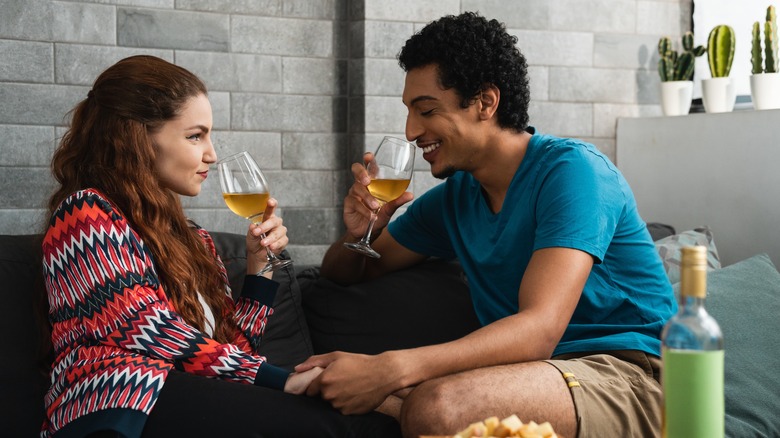 Couple holding hands and drinking wine