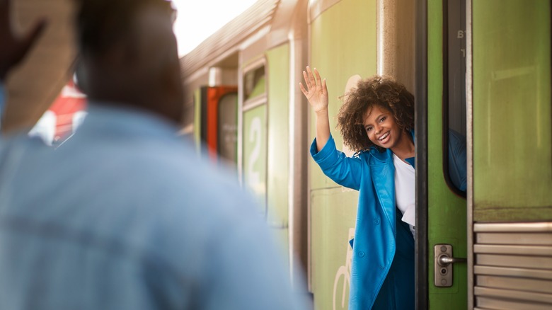 Woman waving at partner from train