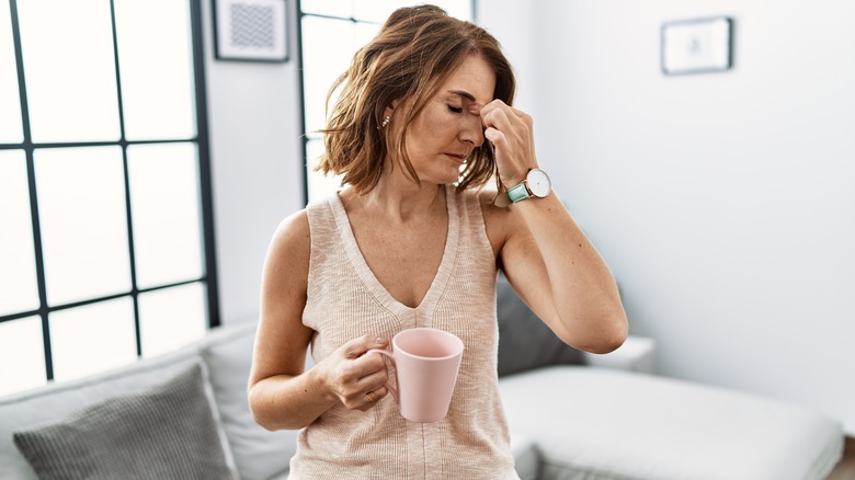 tired woman pinches nose bridge