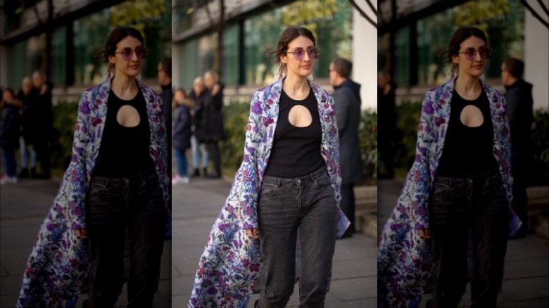 woman with floral duster, black top, washed black denim jeans