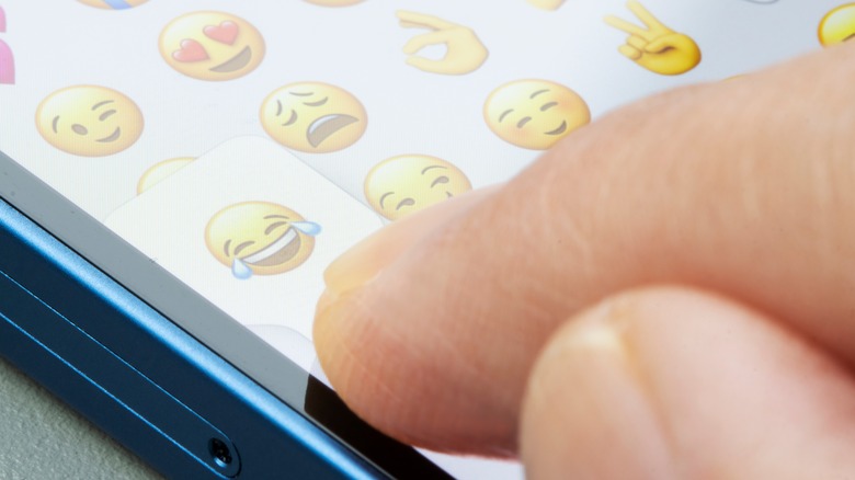 finger pushing emoji on phone