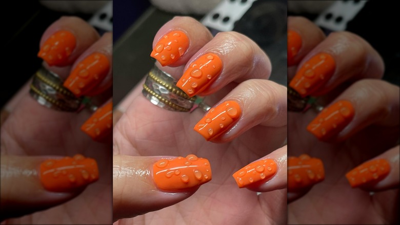 bright orange nails with droplets