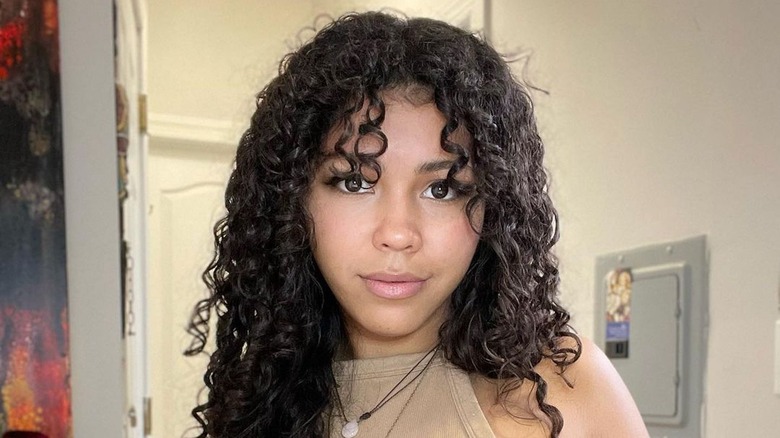 Woman with long curly hair and bangs