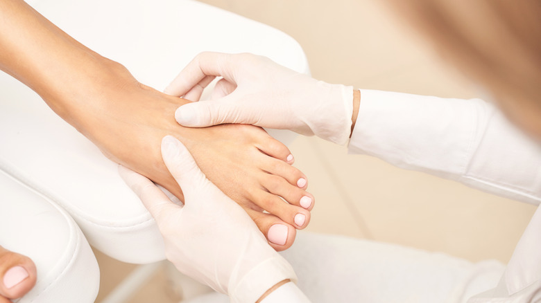 pedicurist massaging person's feet