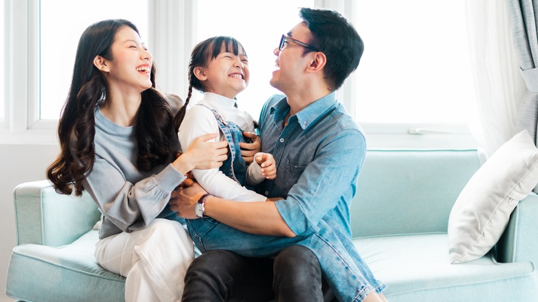 Family laughing together on sofa