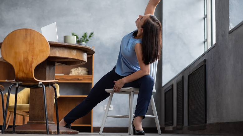 woman practicing yoga in chair